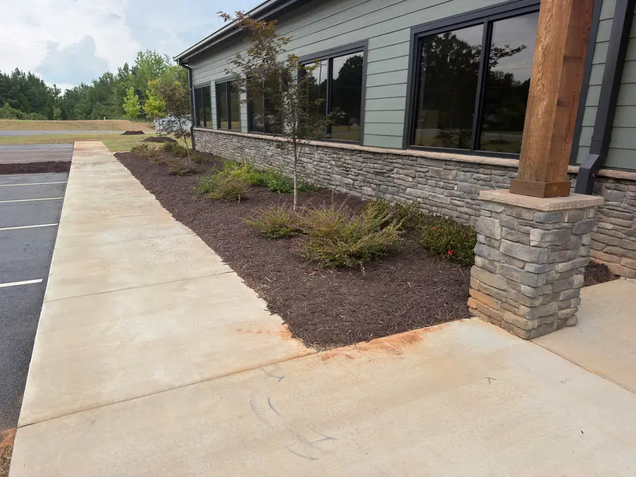 Commercial mulch bed installation along the foundation of a modern building in Kannapolis, NC