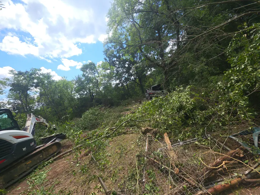 Skid steer with grapple attachment used for land clearing in Concord, NC