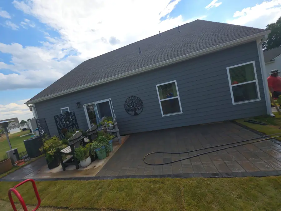 Large L-shaped paver patio installed along the back of a Concord, NC home