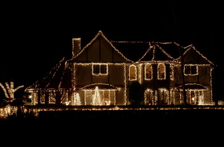 Roofline and gutter holiday lighting outlining a two-story home